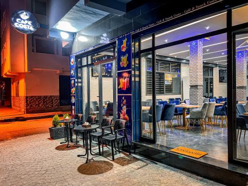 a restaurant with tables and chairs in front of a window at Visit Chamal - Costa Midnight in Oued Laou