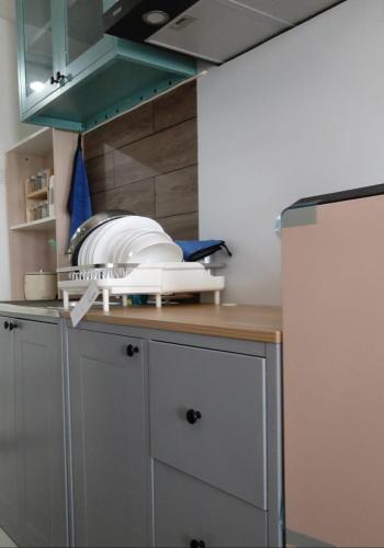 a kitchen counter with some dishes on top of it at Cozy Studio Skylounge Makassar Apartment in Manda