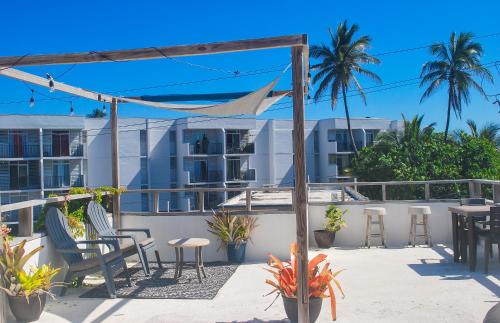 a patio with chairs and tables on a balcony at Casa Sofía Wabi Sabi Apt with Rooftop, Walk to Beach in Luquillo