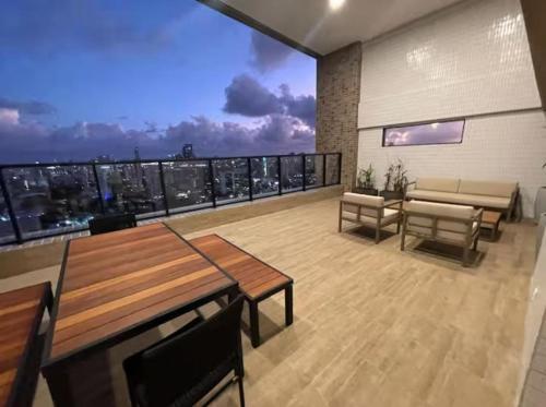 a room with tables and chairs and a large window at Flat no Coração do Recife Próximo ao Consulado Americano in Recife
