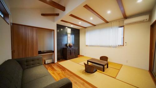 a living room with a couch and a chair at Kunisakisou in Beppu
