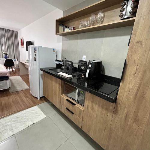 a kitchen with a black counter top and a refrigerator at Royal Luxury 305 in Poços de Caldas