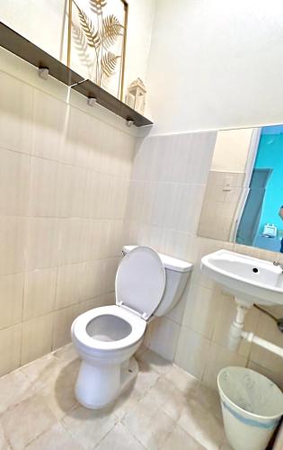 a bathroom with a toilet and a sink at Enchanted Home - Near Enchanted Kingdom in Santa Rosa