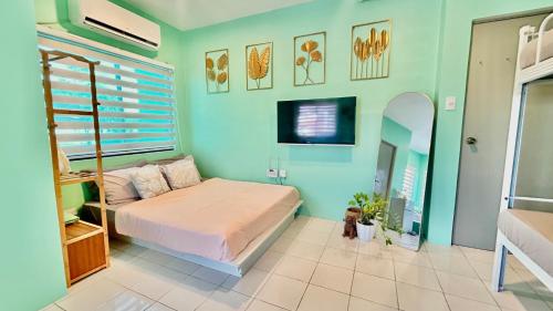 a bedroom with a bed and a tv on the wall at Enchanted Home - Near Enchanted Kingdom in Santa Rosa