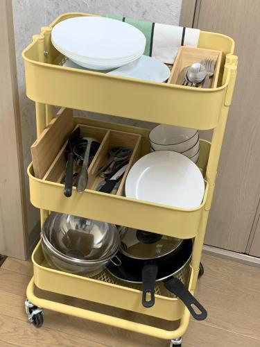 a yellow cart full of dishes and utensils at あびこハウス ABIKO House in Osaka