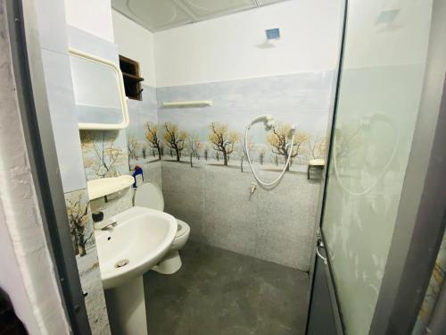 a bathroom with a shower and a toilet and a sink at Sensitha Holiday home in Anuradhapura