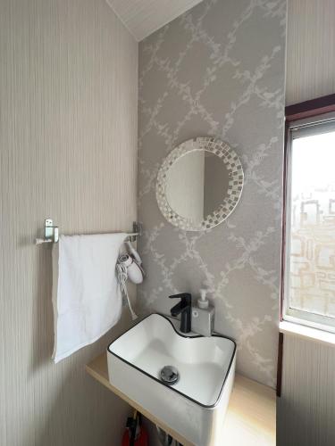 a bathroom with a sink and a mirror at 双魚ノ宿南棟 東京亀戸 スカイツリー徒歩15分 便利な交通 1棟貸切 2ベッドルーム in Tokyo