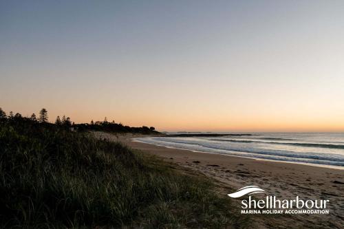 a beach at sunset with a white frisbee on the sand at Seaside Village Retreat in Shellharbour