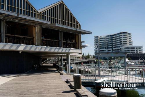 a building on a pier next to a marina at Seaside Village Retreat in Shellharbour