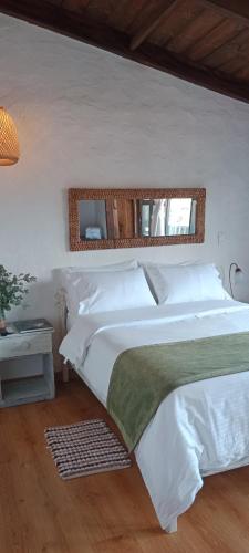 a bedroom with a white bed and a mirror at San Mateo Hotel Campestre in Nobsa