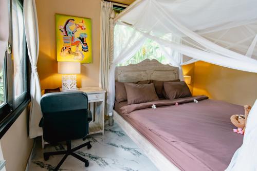 a bedroom with a bed and a desk and a chair at The Onion Collective in Ubud