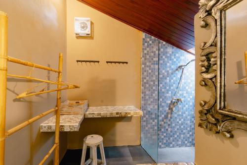 a bathroom with a shower and a sink and a stool at The Onion Collective in Ubud
