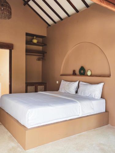 a bedroom with a large bed with an arch above it at Anchor Bed & Bread in Kuta Lombok