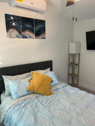 Perfect Getaway-Lovely Cottage House- Near Beaches في نوكوميس: غرفة نوم بها سرير مع وسائد زرقاء