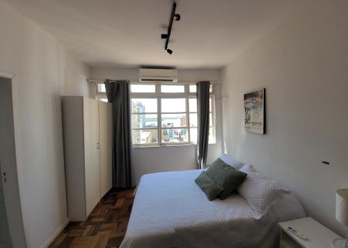 ein kleines Schlafzimmer mit einem Bett und einem Fenster in der Unterkunft 13 andar, Studio, Centro, vista incrivel Guaíba in Porto Alegre