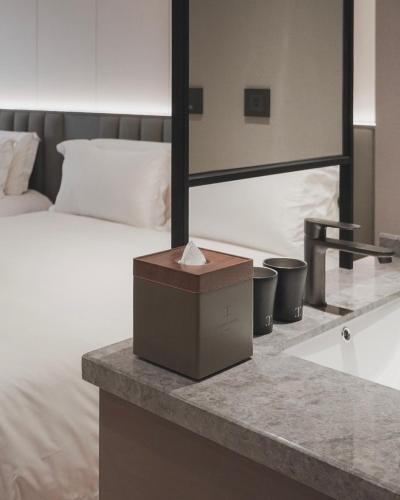 a bedroom with a bed and a box on a counter at Talmud Hotel Classic Taiwan Boulevard in Taichung