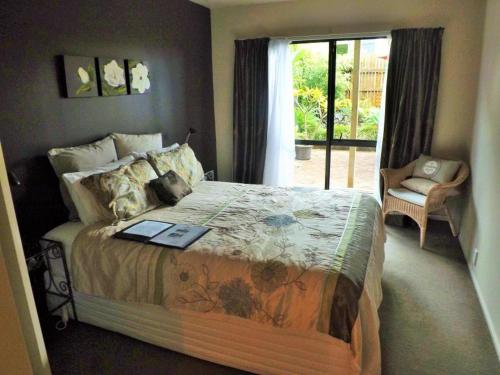 a bedroom with a bed with a book on it at Hosts on the Coast The Harbourview Tairua in Tairua