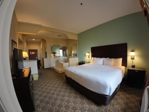 a hotel room with a large bed and a bathroom at Comfort Suites Westchase Houston Energy Corridor in Houston