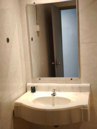 a bathroom with a sink and a mirror at Alamis City Kuala Lumpur - Formerly EDC Hotel Kuala Lumpur in Kuala Lumpur