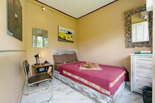 a bedroom with a bed and a mirror and a chair at The Onion Collective in Ubud