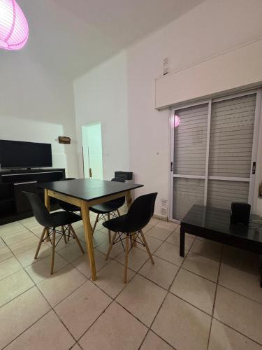 a dining table and chairs in a living room at Alojamiento CENTRICO 1 in Villa María