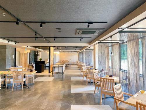 a dining room with tables and chairs and windows at Diamond Hakone Society in Hakone