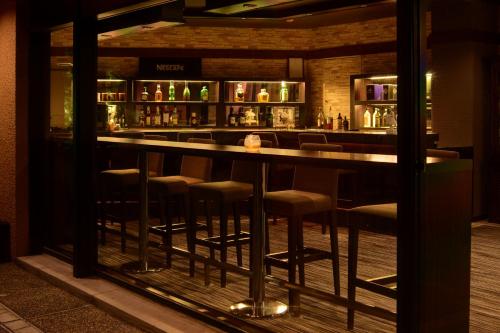 a bar with stools in a room at Diamond Hakone Society in Hakone