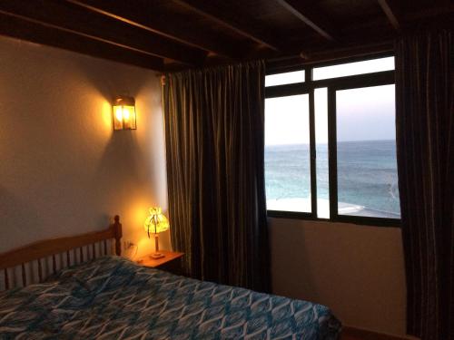 a bedroom with a bed and a window with the ocean at Casa Chanin in Punta Mujeres