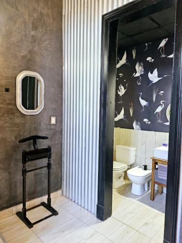 a bathroom with a toilet and a sink and a mirror at El Centurión del Camino Real in Villa Tulumba