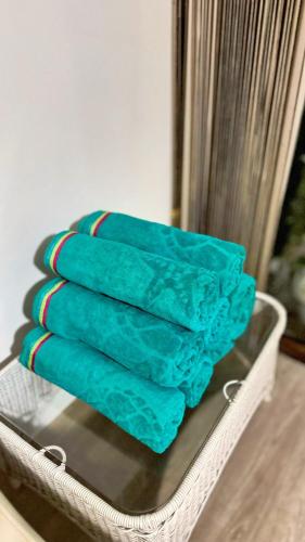 a tray with four turquoise towels in a room at Vacation House Geribá in Búzios
