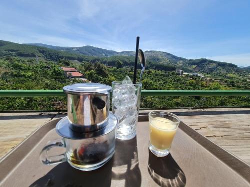un frullatore e un bicchiere di succo d'arancia su un tavolo di Dalat Peace Backpackers Hostel a Da Lat