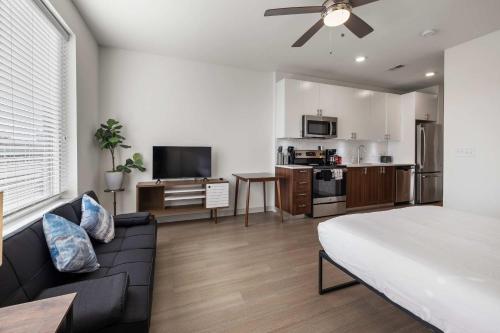 a bedroom with a bed and a living room with a kitchen at Charming Nulu SDO CozySuites 01 in Louisville