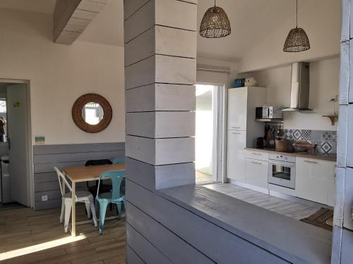 une cuisine avec des armoires blanches et une table et une salle à manger dans l'établissement Maison rénovée proche plage, centre-ville, animaux OK, parking - FR-1-194-296, à La Tranche-sur-Mer