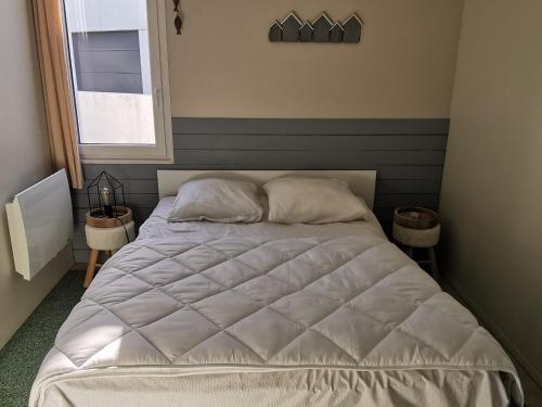 une chambre avec un lit blanc avec deux oreillers dans l'établissement Maison rénovée proche plage, centre-ville, animaux OK, parking - FR-1-194-296, à La Tranche-sur-Mer