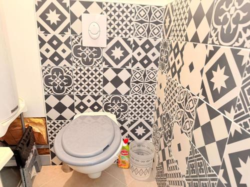 une salle de bain avec toilettes et un mur carrelé dans l'établissement Charmante maison de village à Saint-Pierre-d'Oléron, idéale pour 4 personnes - FR-1-778-52, à Saint-Pierre-dʼOléron