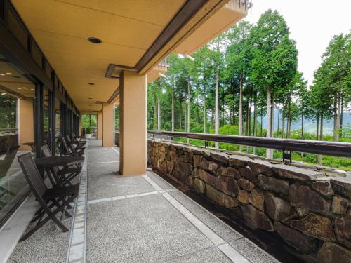 a building with benches and a stone wall at Diamond Hakone Society in Hakone