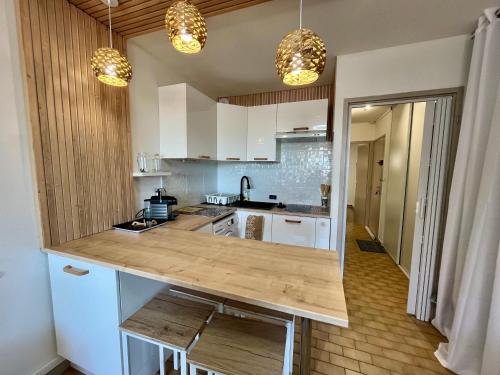 une cuisine avec des armoires blanches et un comptoir en bois dans l'établissement Deux pièces avec vue sur canal et parking privé à Sète - FR-1-338-616, à Sète