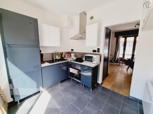 une cuisine avec un évier et un micro-ondes dans l'établissement Duplex en Centre-Ville de Valenciennes Tout Inclus - FR-1-510-232, à Valenciennes