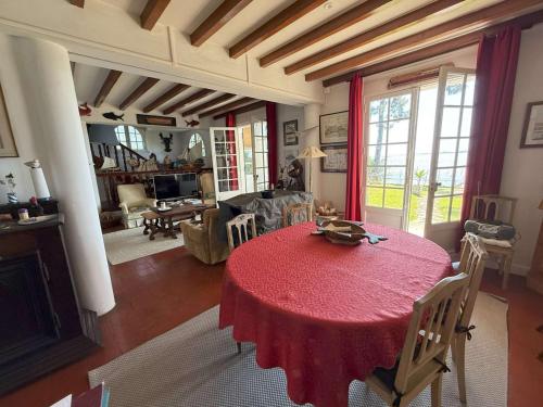 - un salon avec une table et des chaises rouges dans l'établissement Villa au bord du bassin, jardin privé, WIFI, parking, 8 pers. - FR-1-736-61, à Lège-Cap-Ferret