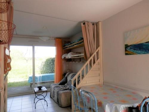 Cette chambre dispose d'un escalier, d'un lit et d'une fenêtre. dans l'établissement Charmant appartement 6 pers avec jardinet, parking sécurisé - FR-1-379-181, à Vieux-Boucau-les-Bains