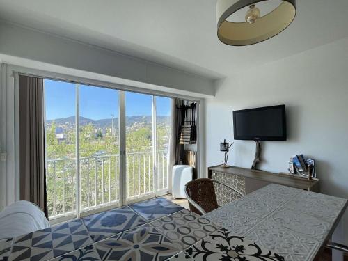 une chambre avec un lit et une grande fenêtre dans l'établissement Studio Accès Plage avec Parking et Ascenseur - FR-1-308-207, au Lavandou