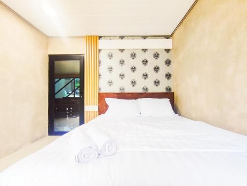 a bedroom with a bed with two towels on it at Napoleon Hills Tambi Tea Gardens View RedPartner in Kejajar