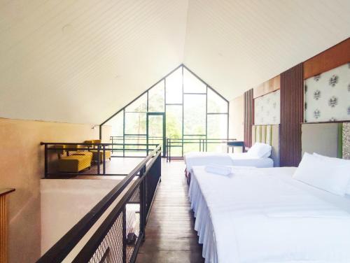 a large room with two beds and a window at Napoleon Hills Tambi Tea Gardens View RedPartner in Kejajar