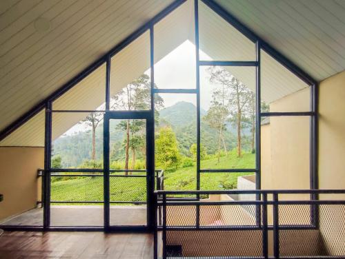 a room with a large window with a view of a mountain at Napoleon Hills Tambi Tea Gardens View RedPartner in Kejajar