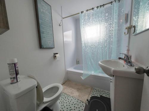 Un baño blanco con inodoro y lavabo. en Logis des Prodiges - Le 773, en Rouyn