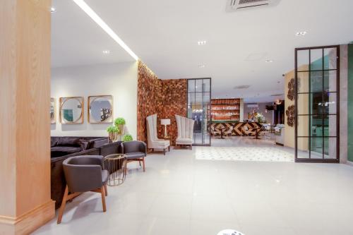 a lobby with chairs and a table in a building at InHouse Hotel Culiacán in Culiacán