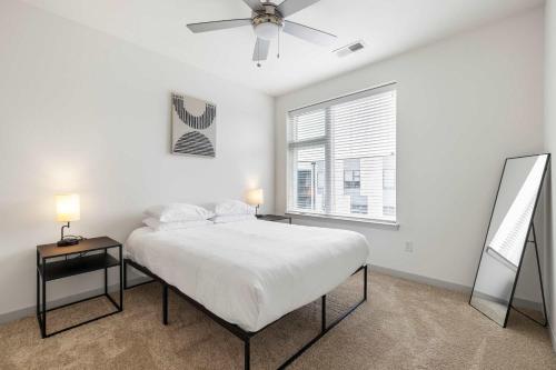 a white bedroom with a bed and a window at Modern Nulu 2BR CozySuites 10 in Louisville