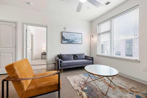 a living room with a couch and a table at Modern Nulu 2BR CozySuites 10 in Louisville