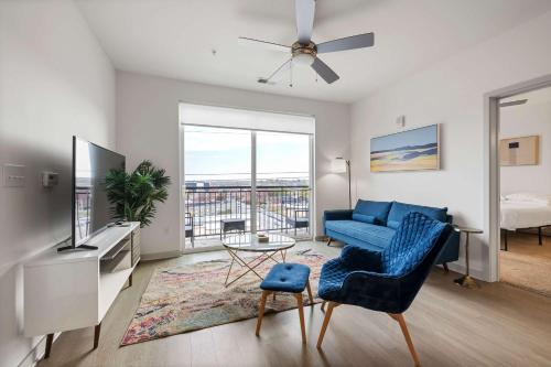 a living room with a blue couch and a tv at Modern Nulu 2BR CozySuites 07 in Louisville