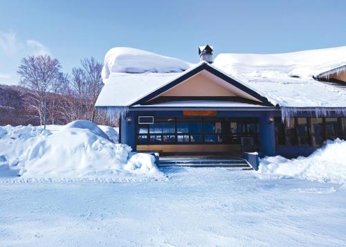 a house covered in snow with a pile of snow at Berjaya Hakkoda Ski Resort in Aomori